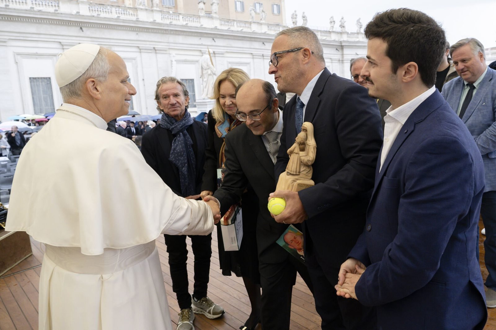 El papa León XIV saluda a miembros del equipo.